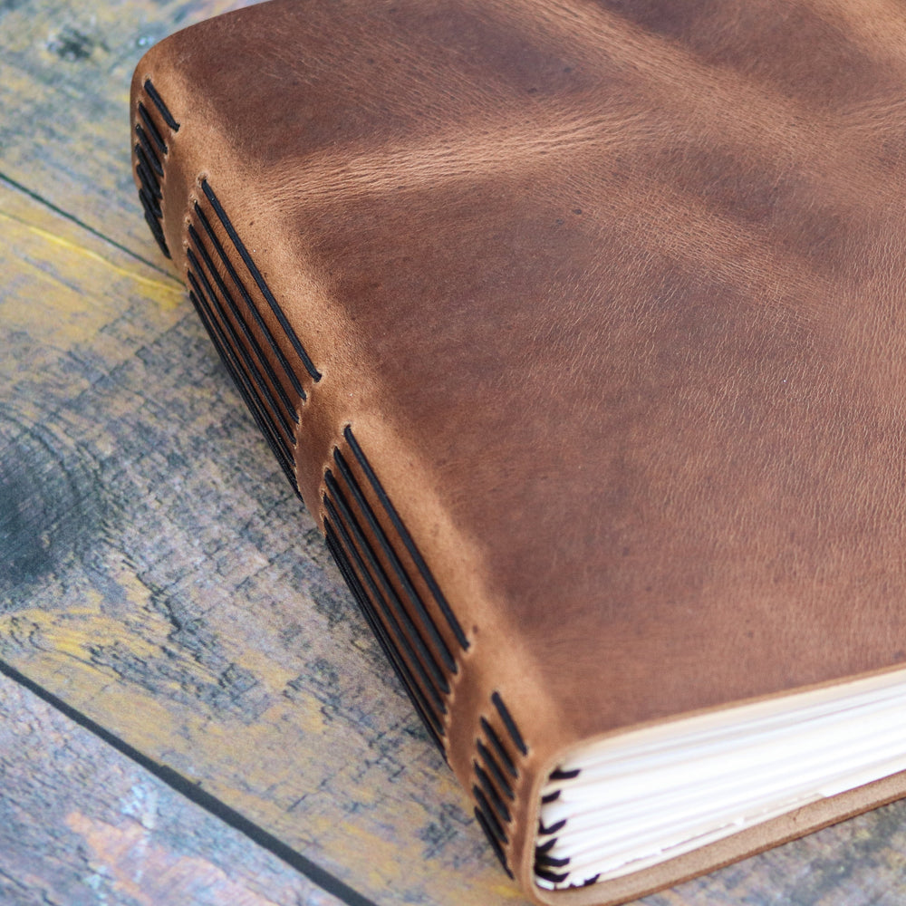 Brown leather-bound book on a wooden surface